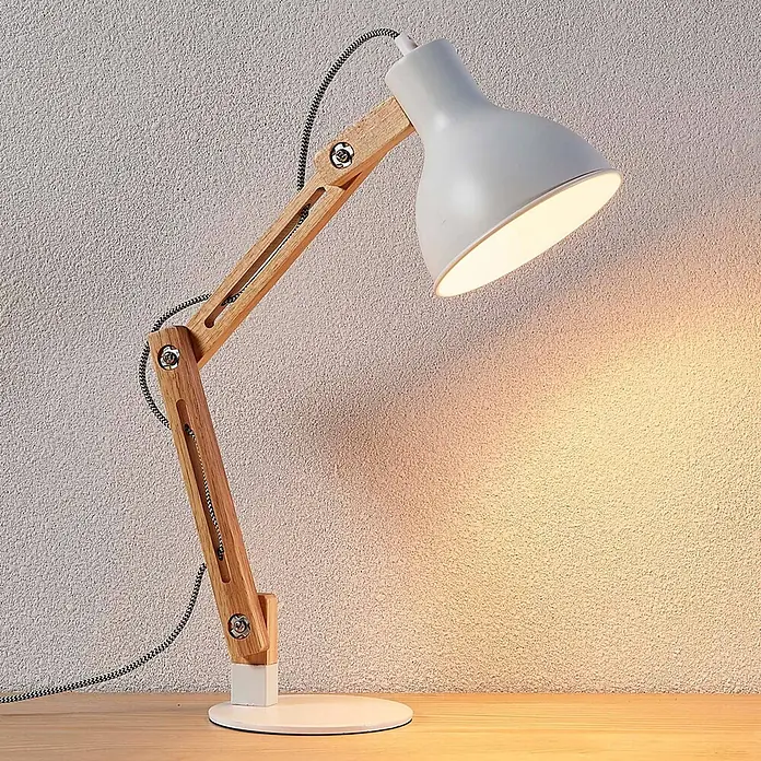 Lindby Tischleuchte Shivanja - L x B x H: 42 x 18 x 46 cm, Holz hell, E27 - Verstellbare Schreibtischlampe mit hellgrauem Metallschirm, natürlichem Holzarm und weißem Sockel, die warmes Licht auf einer Holzfläche spendet.