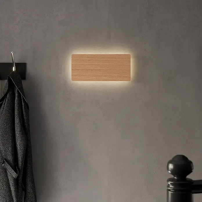 Envostar Wandleuchte Tavola - L x B x H: 4 x 35 x 16 cm, Holz hell, Holz hell, G9 - Rechteckige Wandleuchte aus Holz mit warmer Hintergrundbeleuchtung, an grauer Wand über Garderobe montiert.