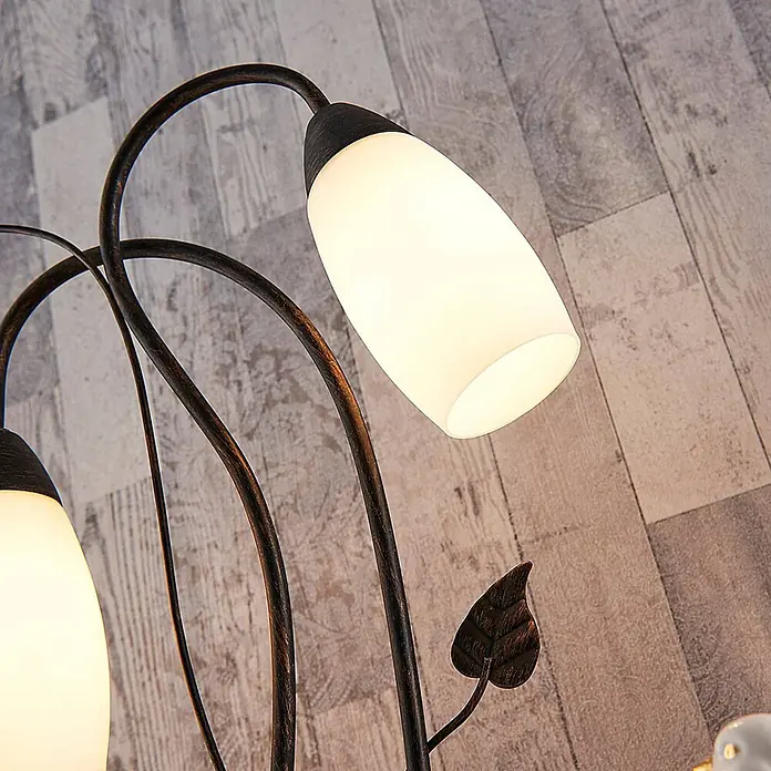Lindby Tischleuchte Stefania - L x B x H: 28 x 28 x 40 cm, braun / rost, E14 - Stehlampe mit kunstvollen dunklen Metallarmen, satinierten Glasschirmen und einem Zierblatt, auf Holzfußboden.