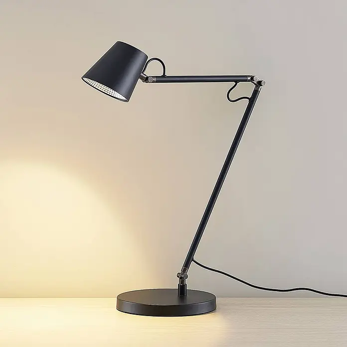 Lucande Tischleuchte Tarris - L x B x H: 40 x 18 x 46 cm, schwarz, schwarz - Schwarze, verstellbare Schreibtischlampe auf einem Holztisch, die warmes Licht auf die Wand wirft.
