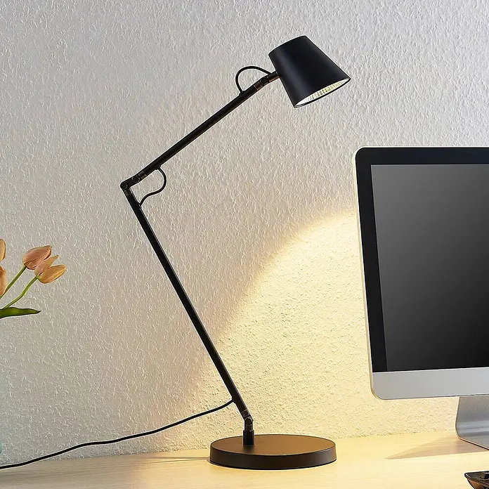 Lucande Tischleuchte Tarris - L x B x H: 40 x 18 x 46 cm, schwarz, schwarz - Schwarze, verstellbare Schreibtischlampe beleuchtet einen Arbeitsbereich neben einem Monitor.