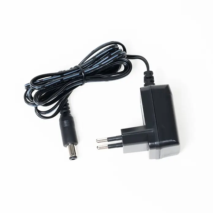 Lindby Tischleuchte Ailina - schwarz, schwarz - Schwarzes Netzteil mit europäischem Stecker und Hohlstecker, verbunden durch ein aufgerolltes Kabel.