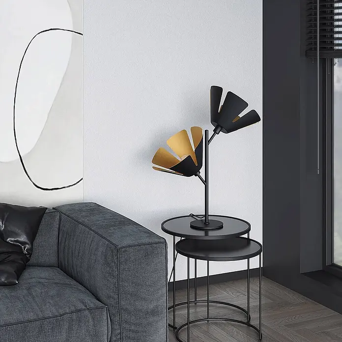 Lucande Tischleuchte Jemmily - L x B x H: 30 x 30 x 55 cm, schwarz, E14 - Moderne schwarz-goldene Blumenvase auf runden, verschachtelten schwarzen Beistelltischen neben einem dunkelgrauen Sofa.