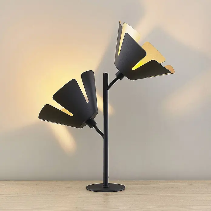 Lucande Tischleuchte Jemmily - L x B x H: 30 x 30 x 55 cm, schwarz, E14 - Schwarze Metall-Tischleuchte mit zwei blumenförmigen Köpfen und goldenem Inneren, die warmes Licht auf eine Holzoberfläche wirft.