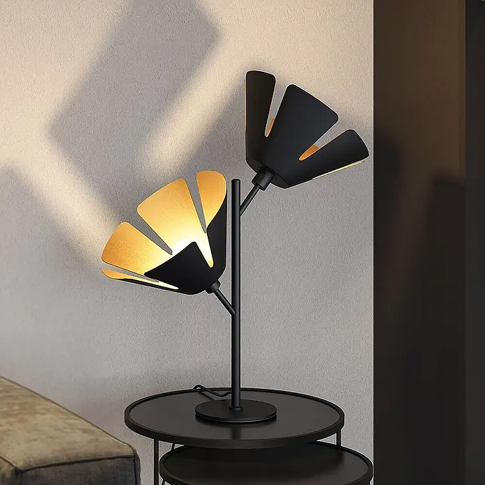 Lucande Tischleuchte Jemmily - L x B x H: 30 x 30 x 55 cm, schwarz, E14 - Schwarze Metall-Tischleuchte mit zwei blütenförmigen, innen goldenen Schirmen, auf einem Beistelltisch.