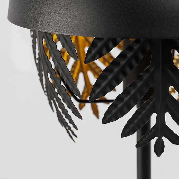 Lucande Tischleuchte Aparas - L x B x H: 28 x 28 x 54 cm, schwarz, schwarz, E27 - Nahaufnahme eines schwarzen, strukturierten Metall-Lampenschirms mit filigranen schwarzen Metallblättern und warmgoldenem Inneren.