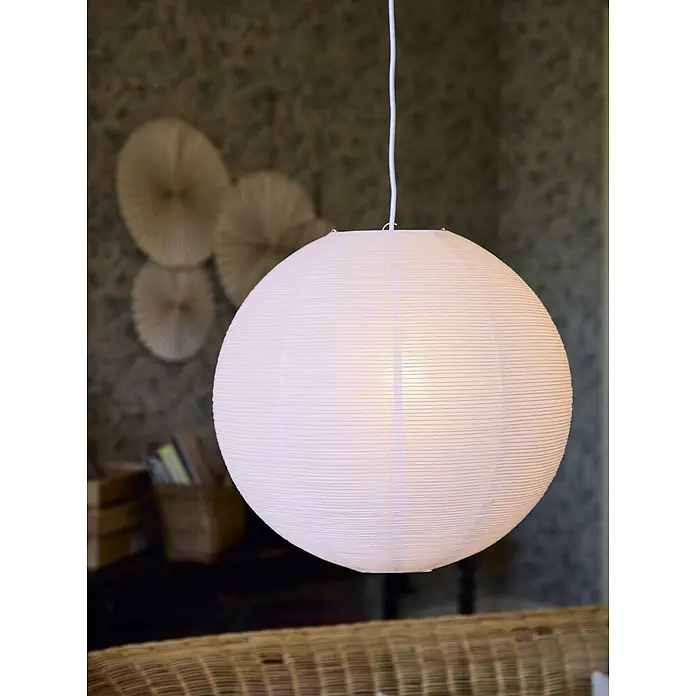 PR Home Pendelleuchte Lampenschirm -  - Beleuchtete, kugelförmige, weiße Papierlaterne mit Rippenstruktur, die ein sanftes Licht spendet. Hintergrund zeigt verschwommene Dekoration.