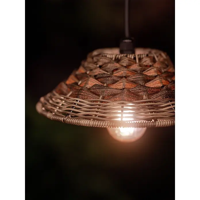 PR Home Pendelleuchte 27cm Outdoor - 40 W, E27 - Nahaufnahme einer Hängelampe mit geflochtenem braun-hellem Korbschirm, die ein warmes Licht abgibt.