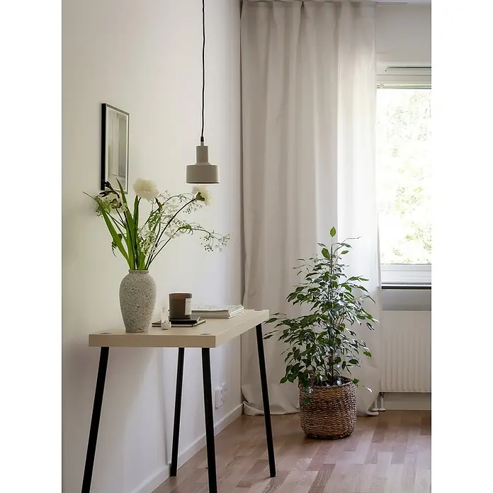 PR Home Pendelleuchte Solo - 25 W, E27 - Eine minimalistische Raumecke mit einem hellen Konsolentisch, schwarzen Beinen, einer Blumenvase, einer grauen Hängelampe und einer großen Pflanze.