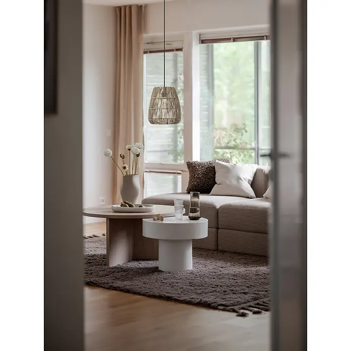 PR Home Pendelleuchte Saigon - 40 W, E27 - Geflochtene Rattan-Pendelleuchte hängt in einem modernen Wohnzimmer über Couchtischen und einem Sofa.