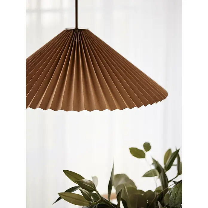 PR Home Pendelleuchte Dora - 25 W, E27 - Brauner plissierter Papierschirm hängt über grünem Laub.