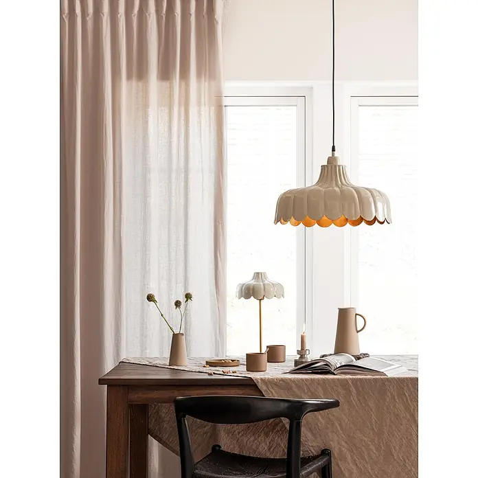 PR Home Pendelleuchte Wells - 25 W, E27 - Eine cremefarbene Pendelleuchte mit Wellenrand hängt über einem Esstisch, ergänzt durch eine passende Tischlampe.