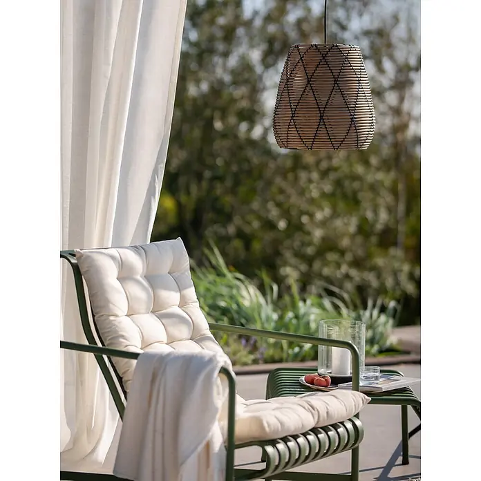 PR Home Pendelleuchte 38cm Outdoor - 40 W, E27 - Grüner Metall-Loungesessel mit cremefarbenem Kissen und Decke im Freien, darüber eine gewebte Pendelleuchte.