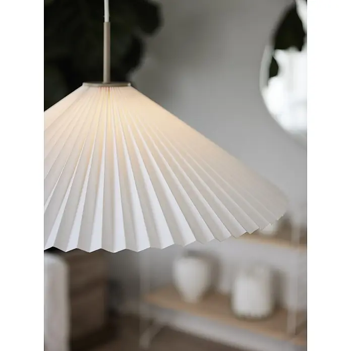 PR Home Pendelleuchte Dora - 25 W, E27 - Gefalteter weißer Papierlampenschirm hängt in einem modernen Interieur und strahlt warmes Licht aus.