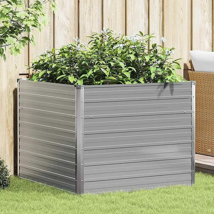 Furnicato Hochbeet - Metall, Grau - Quadratisches, graues Hochbeet aus Metall mit geriffelten Seiten, gefüllt mit Grünpflanzen und weißen Blüten, auf Gras im Freien.