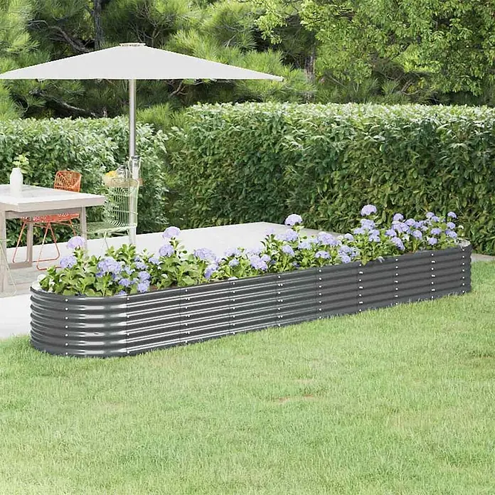 Furnicato Hochbeet - 368 x 80 x 36 cm, Stahl, Anthrazit - Langes, dunkelgraues Hochbeet aus Wellblech mit lila Blumen auf grünem Rasen neben einer Terrasse.