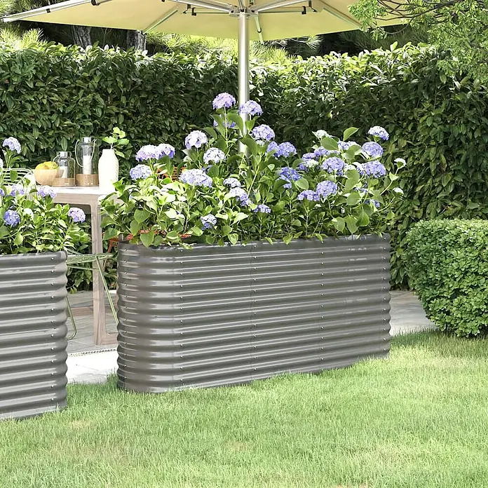 Furnicato Hochbeet - 152 x 40 x 68 cm, Stahl, Grau - Zwei dunkelgraue Hochbeete aus Wellblech in einem üppigen Garten, gefüllt mit leuchtend blauen Hortensien.