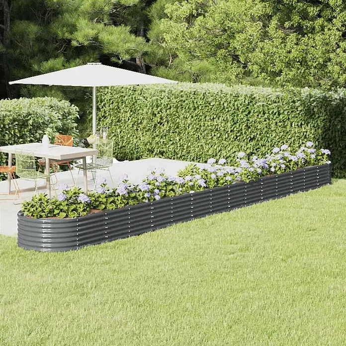 Furnicato Hochbeet - 620 x 80 x 36 cm, Stahl, Anthrazit - Dunkelgraues Hochbeet aus Wellblech, mit hellvioletten Blumen gefüllt, grenzt an Terrasse und Rasen.