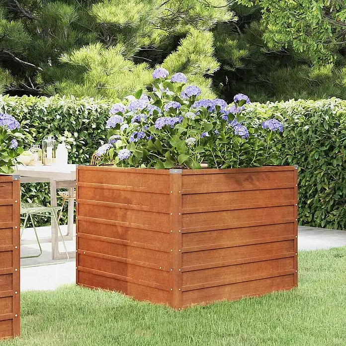 Furnicato Hochbeet - 100 x 100 x 77 cm, Stahl, Braun - Großes rechteckiges Pflanzgefäß aus braunem Holz, gefüllt mit lila Hortensien, im Garten.