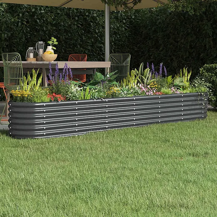 Furnicato Hochbeet - 260 x 40 x 36 cm, Stahl, Anthrazit - Großes, rechteckiges Hochbeet aus dunkelgrauem Wellblech, mit verschiedenen Pflanzen gefüllt, auf Rasen.