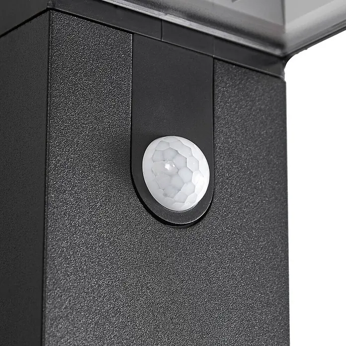 Prios Außenwandleuchte Aurino - 20,5 x 9 x 20 cm, schwarz, IP44 - Nahaufnahme eines schwarzen, texturierten Geräts mit eingebettetem weißem Bewegungsmelder.