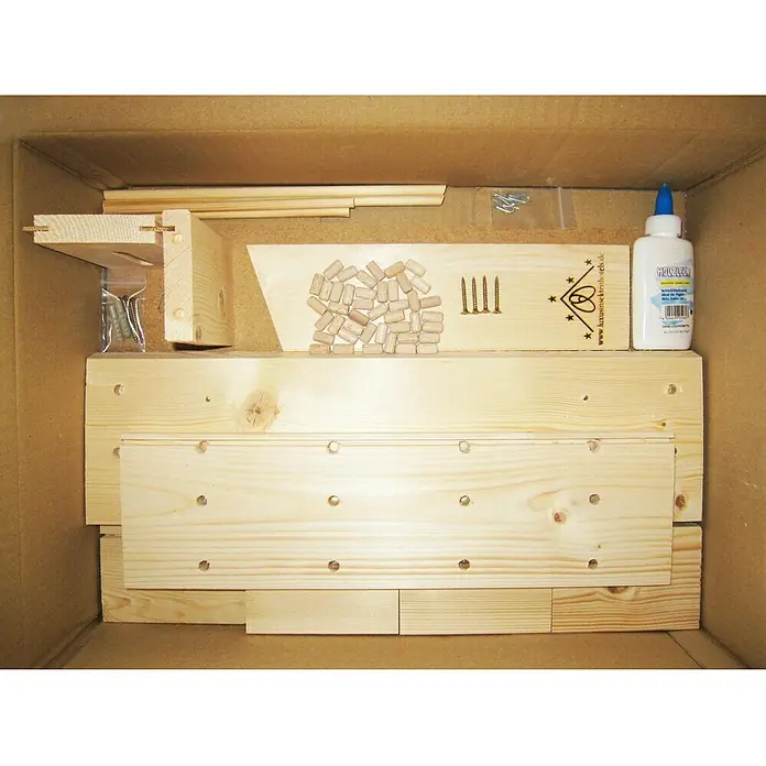 Dobar Insektenhotel Landhaus Komfort47 x 12,5 x 34 cm, Kiefer - Das Bild zeigt ein Bausatz mit Holzbrettern, Dübeln, Schrauben und Kleber, verpackt in einem Karton. Ideal zum Basteln und Bauen eigener Projekte.