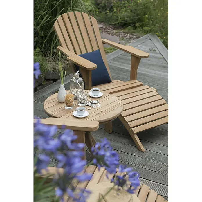 Bene Living Garten-Beistelltisch Burton - L x B x H: 60 x 60 x 50 cm, Teakholz, Rund, Natur - Adirondack-Stuhl aus Holz mit Fußstütze und Beistelltisch auf einer Terrasse, bereit für Entspannung im Garten mit Kaffee und Snacks.