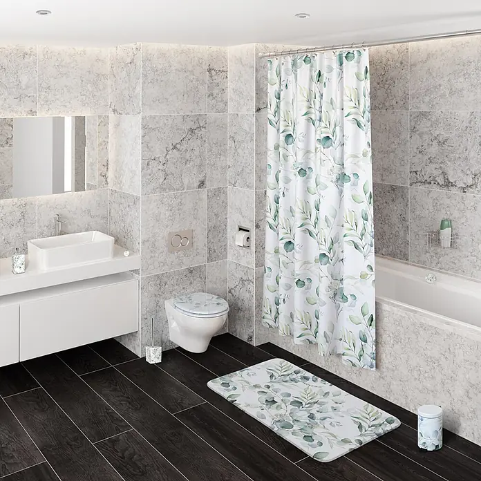 SANILO WC-Sitz Eukalyptus mit Schnellverschluss - MDF, Weiß, Mit Absenkautomatik - Ein Badezimmer mit weißem Duschvorhang, Badematte, Toilettensitzbezug, Seifenspender, Toilettenbürstenhalter und Mülleimer, alle mit grünem Eukalyptusblattmuster.