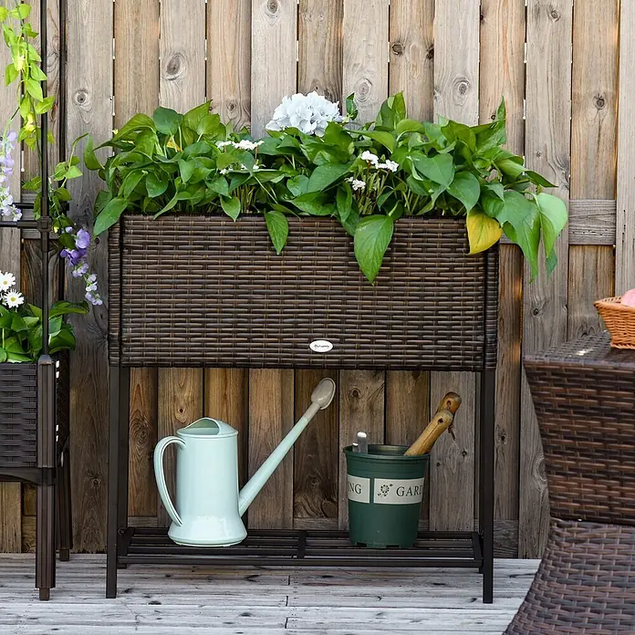 Outsunny Kräuterhochbeet - Material: Metall - Braunes geflochtenes Hochbeet mit Pflanzen, auf dunklem Metallständer, mit Gartengeräten auf der unteren Ablage.