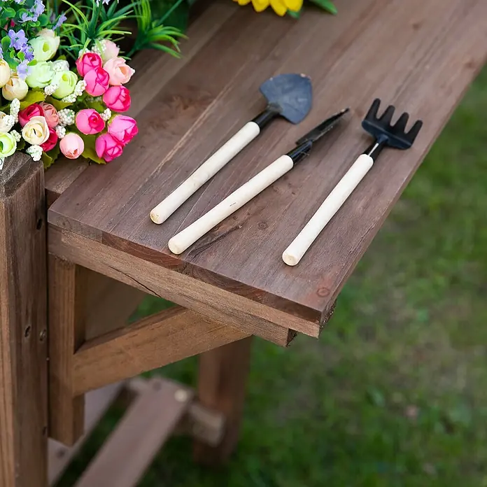 Outsunny Kräuterhochbeet - Material: Holz - Dreiteiliges Set kleiner Gartengeräte mit Holzgriffen und dunklen Metallköpfen, auf einem Holztisch.