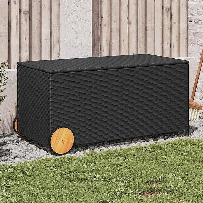Furnicato Garten-Aufbewahrungsbox - Schwarz, Naturmaterialien - Schwarze Outdoor-Aufbewahrungsbox in Rattanoptik mit Holzrädern, auf Kies neben Gras.