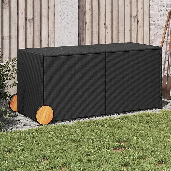 Furnicato Garten-Aufbewahrungsbox - Schwarz, Naturmaterialien - Schwarze Rattan-Gartenaufbewahrungsbox mit Holzrädern, draußen auf Kies und Gras.