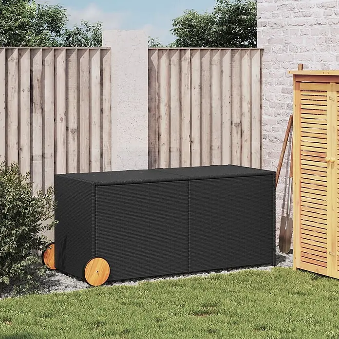Furnicato Garten-Aufbewahrungsbox - Schwarz, Naturmaterialien - Große schwarze Rattan-Gartenbox mit Holzrädern, in einem Gartenambiente.