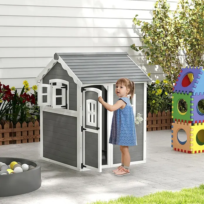 Outsunny Spielhaus - L x B x H: 110 x 104,5 x 137 cm, Holz, Grau - Ein kleines Kind in einem blauen Kleid öffnet die Tür eines grau-weißen Holzspielhauses im Garten.
