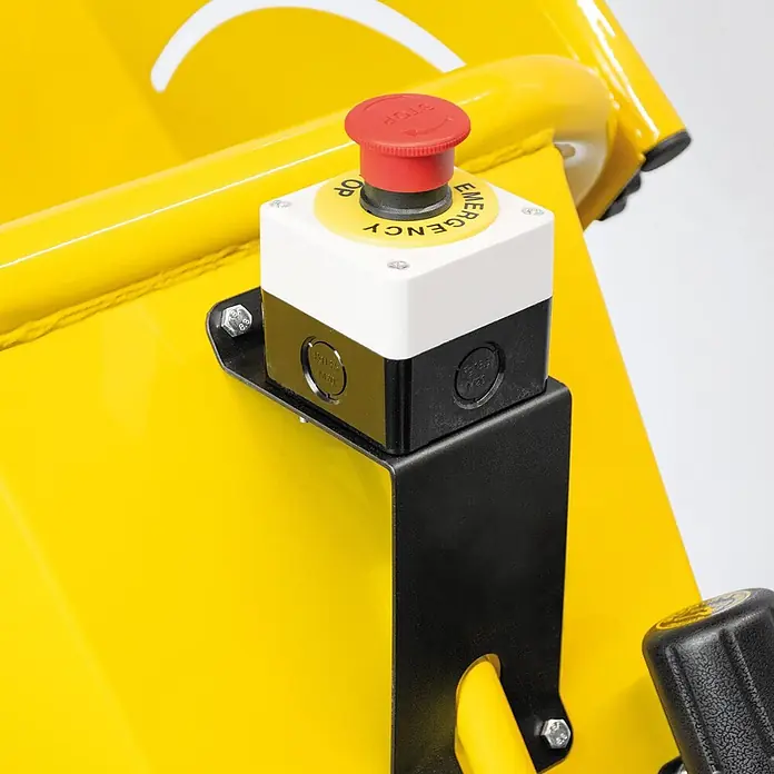 Bamato Benzin-Häcksler HACK-100 inkl. Abdeckplane - Max. Aststärke: 100 mm, 4,1 kW, Hubraum: 196 cm³ - Roter Not-Aus-Taster mit gelber Beschriftung, montiert auf einer weiß-schwarzen Steuerbox, an leuchtend gelben Maschinen befestigt.