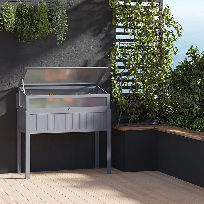 Outsunny Kräuterhochbeet - Material: Holz - Graues Hochbeet/Frühbeet aus Holz mit offener, durchsichtiger Abdeckung, bepflanzt, auf einer Holzterrasse.