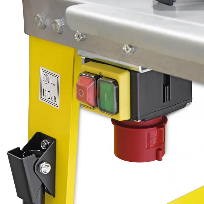 BAMATO Tischkreissäge BCS-500PRO 400V 4200W 500mm Sägeblatt -  - Nahaufnahme eines Maschinenbedienfelds mit roten Stopp- und grünen Starttasten, Stromanschluss und 110 dB Lärmpegelaufkleber auf gelbem Rahmen.