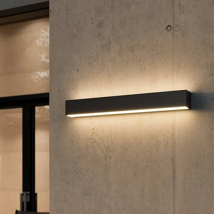 Lucande Außenwandleuchte Lengo - schwarz, schwarz, IP65 - Rechteckige dunkelgraue LED-Wandleuchte, die eine Betonwand mit warmem Ober- und Unterlicht beleuchtet.