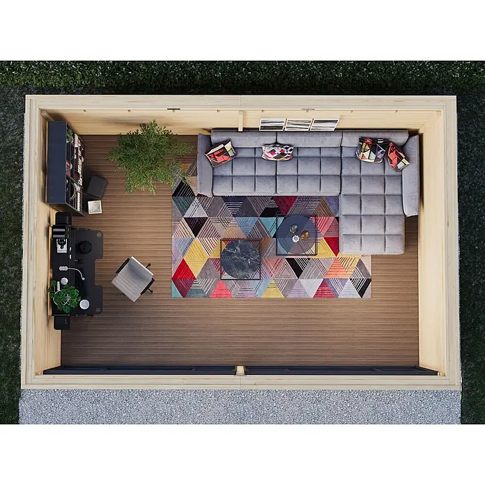 Fjordholz Gartenhaus Office IsoSlide 11 - Außenmaß inkl. Dachüberstand (B x T): 662,2 x 451,6 cm, Holz, Naturbelassen - Holz-Gartenhaus-Interieur mit grauem Sofa, buntem Teppich, schwarzem Schreibtisch und Stuhl, als Wohn- und Arbeitsbereich.