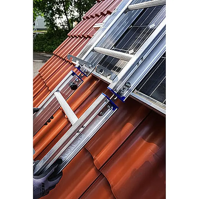 Mauderer Dachleiter Bavaria Wartungsleitern für Photovoltaik-Anlagen Leiterlänge 2,0m 7 Spros - Anzahl Tritte: 7 Stk., Belastbarkeit: 150 kg, Aluminium - Aluminium-Dachleiternsystem mit blauen Akzenten auf einem roten Ziegeldach neben Solarpaneelen, von einer behandschuhten Hand gehalten.