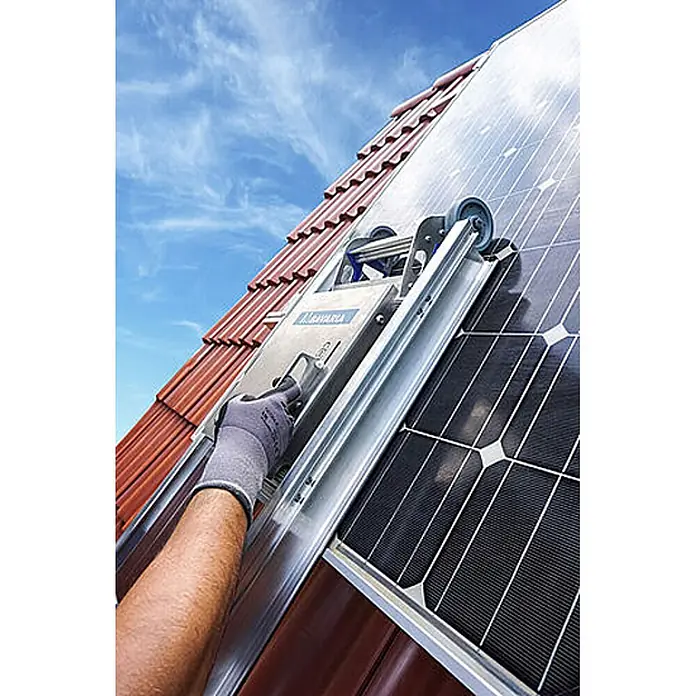 Mauderer Dachleiter Bavaria Wartungsleitern für Photovoltaik-Anlagen Leiterlänge 2,0m 7 Spros - Anzahl Tritte: 7 Stk., Belastbarkeit: 150 kg, Aluminium - Silberne Dachhebevorrichtung, von einer behandschuhten Hand bedient, auf einem Ziegeldach neben Solarpaneelen.