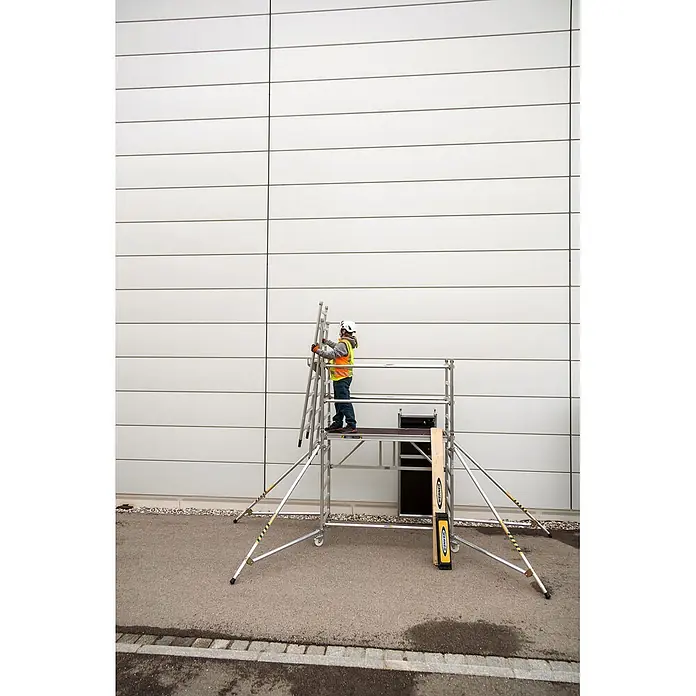 Werner Rollgerüst Klappgerüst Tower 3T nach DIN Norm EN 1004-1 AH 7,55m - Arbeitshöhe: 7.550 m, Belastbarkeit Plattform: 216 kg - Mobiles Aluminium-Rollgerüst mit Person auf der Plattform, hält eine Leiter. Zum Arbeiten in der Höhe.
