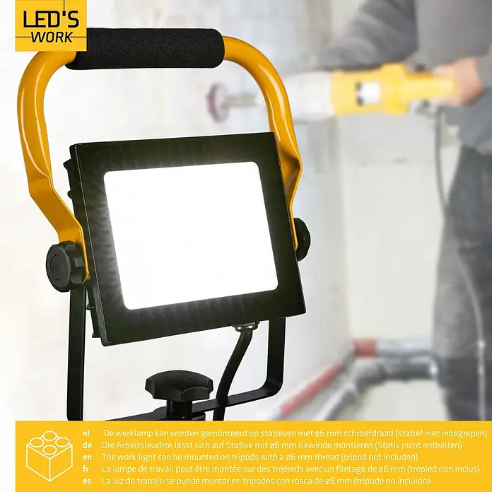 LED's work LED-Arbeitsleuchte - L x B x H: 18 x 21 x 28 cm, 4.200 lm, Lichtfarbe: Neutralweiß, Netzbetrieben, IP65 - Eine helle LED-Arbeitsleuchte mit gelbem Griff und schwarzem Rahmen, die einen Arbeitsbereich beleuchtet. Stativmontierbar.