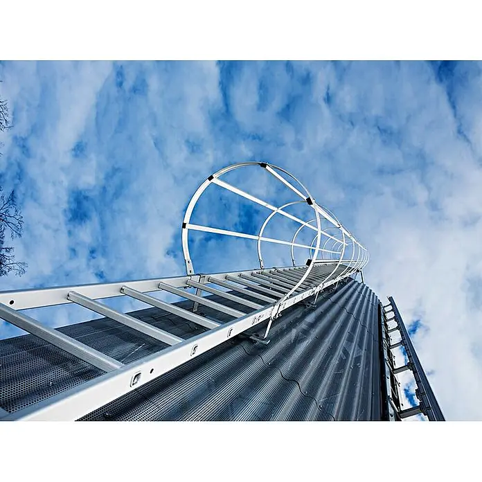 Munk Anlegeleiter ortsfeste Steigleitern Aluminium, 15,96m SH - Aluminium - Silberne Steigleiter mit Rückenschutz an hohem Metallsilo, himmelwärts gerichtet.