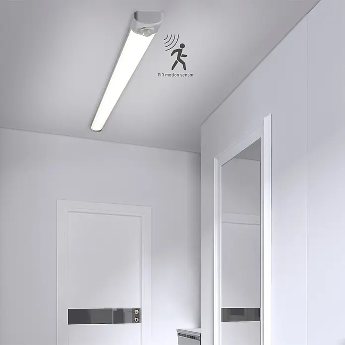 LED's work LED-Feuchtraumlichtleiste Sensor - Länge: 120 cm, 36 W, IP40 - Lineare LED-Deckenleuchte mit integriertem PIR-Bewegungssensor, beleuchtet einen weißen Flur.
