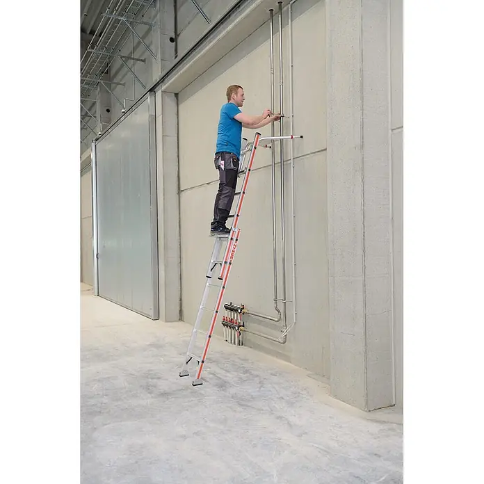 Hymer Schiebeleiter Schiebeleiter mit gebogener Traverse und Wandlaufrollen 2x16 Sprossen - Anzahl Tritte: 16 Stk., Arbeitshöhe: 9.050 m, Aluminium - Mann auf einer silber-orangenen Klappleiter, arbeitet an Rohren an einer Betonwand in einer Industriehalle.