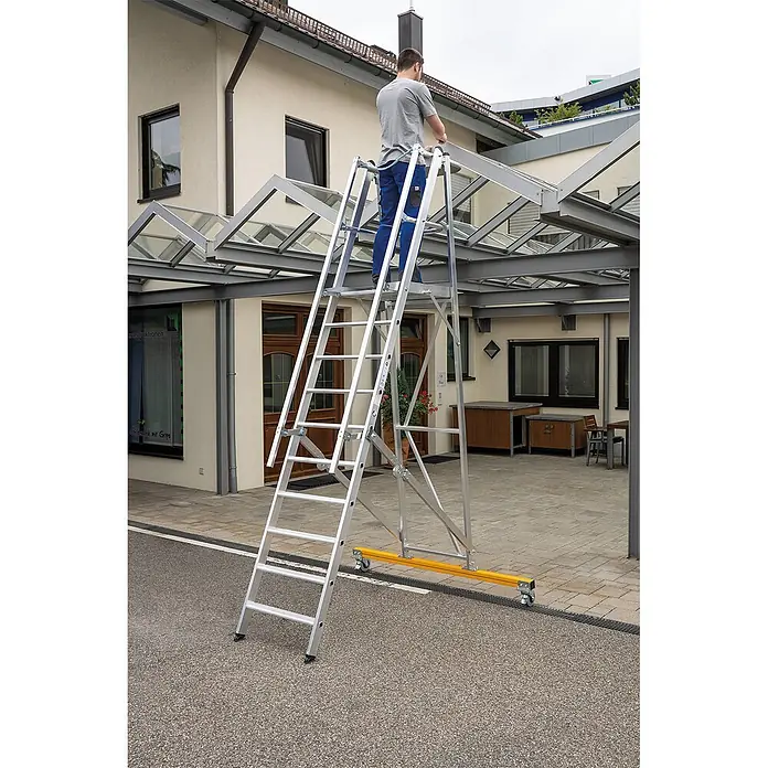Munk Podestleiter Podestleiter klappbar 12 Stufen - Anzahl Tritte: 12 Stk., Arbeitshöhe: 4.800 m, Aluminium - Mann auf mobiler Alu-Arbeitsbühne mit Rollen, nutzt sie für Zugang zu Glasvordach.