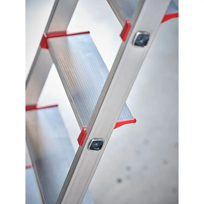 Altrex Stehleiter Nimba Stufenstehleiter einseitig begehbar 5 Stufen - Anzahl Tritte: 5 Stk., Arbeitshöhe: 3.100 m, Aluminium - Nahaufnahme einer silbernen Aluminium-Klappleiter mit roten Akzenten an den Stufen.
