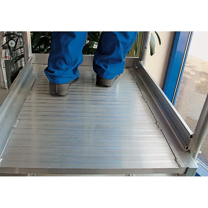 Munk Treppenpodest Podestleiter fahrbar Stahl-Gitterrost 8 Stufen - Anzahl Tritte: 8 Stk., Arbeitshöhe: 3.900 m, Aluminium - Person steht auf einer geriffelten Aluminiumplattform mit rutschfester Oberfläche.