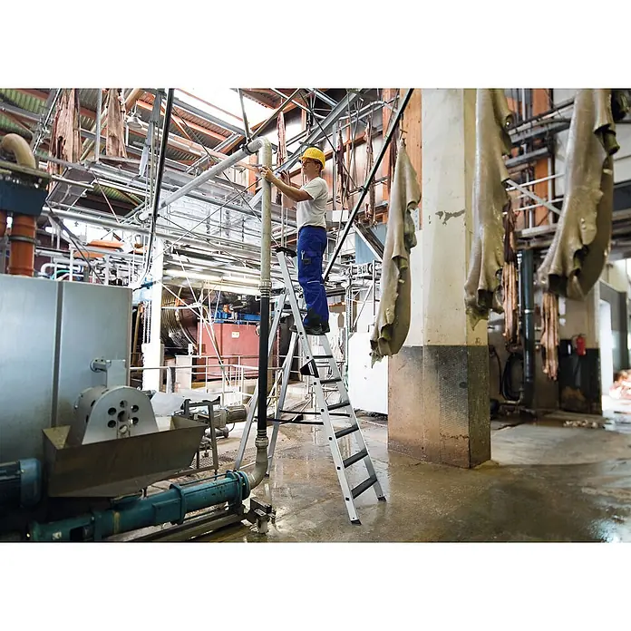 Munk Stehleiter Stehleiter mit clip-step 5 Stufen - Anzahl Tritte: 5 Stk., Arbeitshöhe: 3.150 m, Aluminium - Arbeiter auf einer silbernen Aluminium-Stehleiter, der hohe Rohre in einer Industrieanlage erreicht.